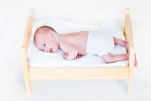 小新生儿躺在玩具床上图片下载