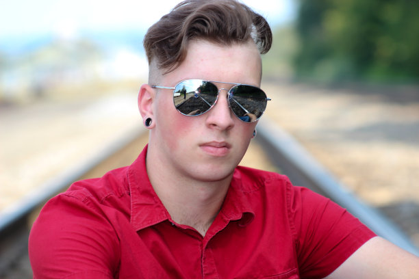 少年在火车轨道上摆姿势的特写图片下载