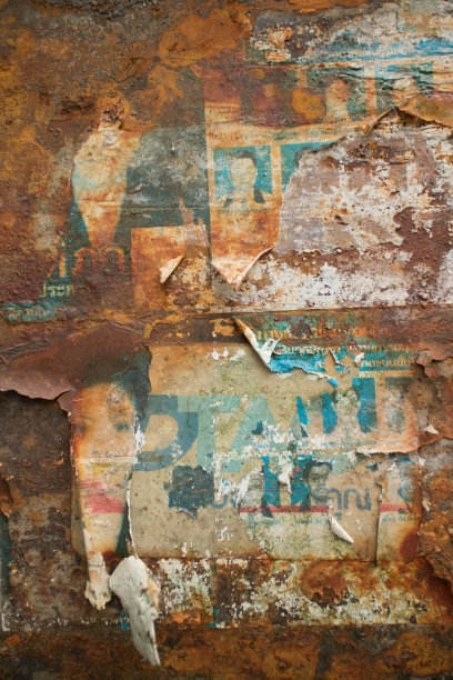 在泰国锈迹斑斑的金属墙上，久经风霜的纸传单图片下载