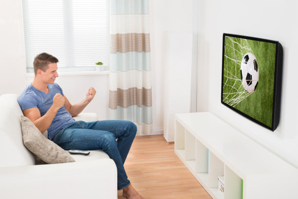 男人在电视上看体育节目图片下载