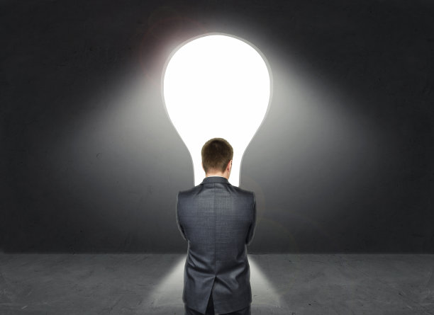 商人站在亮大主意的灯泡前图片下载