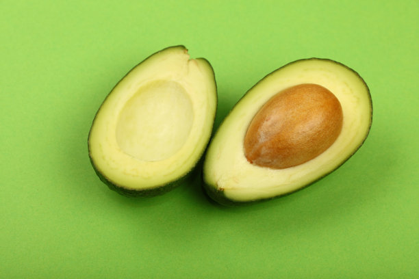 两半新鲜的牛油果，用绿色的纸包起来图片下载