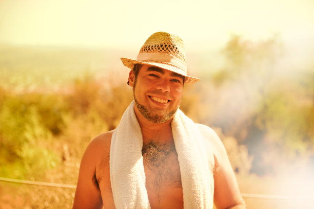 留着胡子，戴着草帽，在度假时微笑的时髦小伙图片下载
