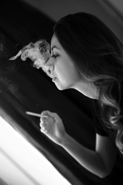 可爱女孩吸烟。图片下载