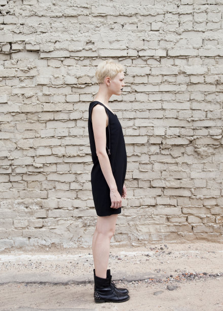 穿黑衣服的女孩靠在砖墙上图片下载