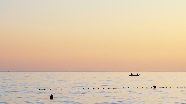 日落时分，海滩上渔民捕鱼的剪影图片下载