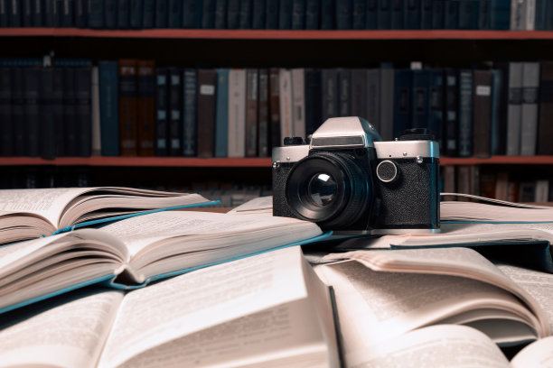 旧相机在许多打开的书上图片下载