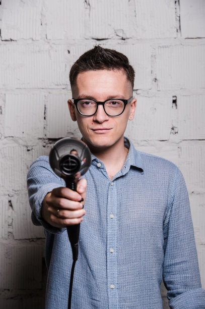 男性时尚的理发师拿着吹风机和射击图片下载