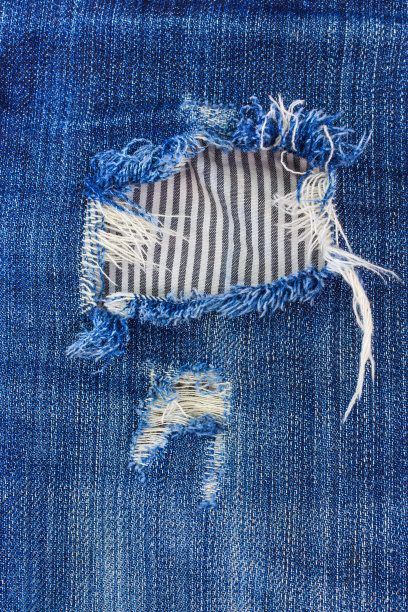 蓝色撕裂牛仔牛仔裤纹理。图片下载