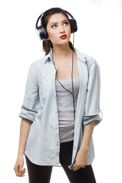 年轻漂亮的女人喜欢戴着大耳机听音乐图片下载