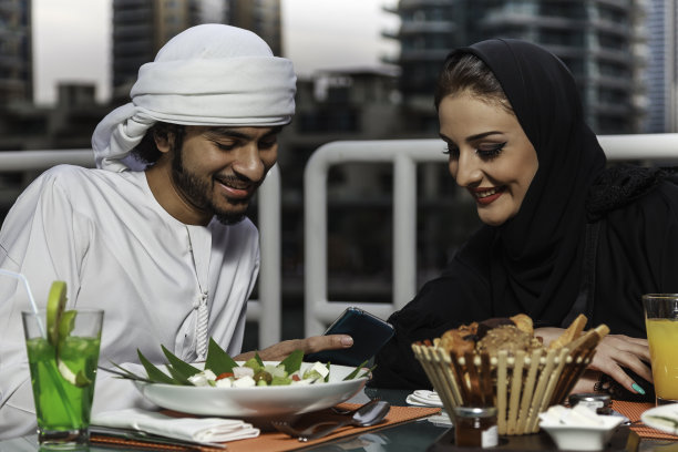 阿拉伯夫妇用餐后看手机图片下载