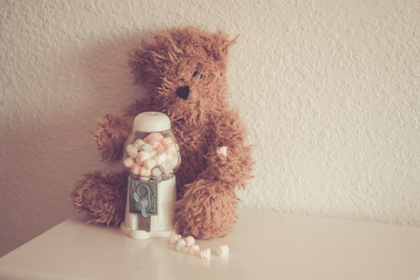 小泰迪熊拿着盒子糖果坐下来图片下载