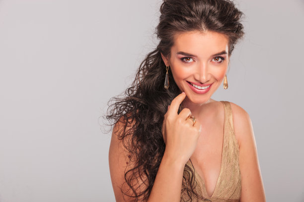 优雅的女孩微笑着，抚摸着她的脸图片下载