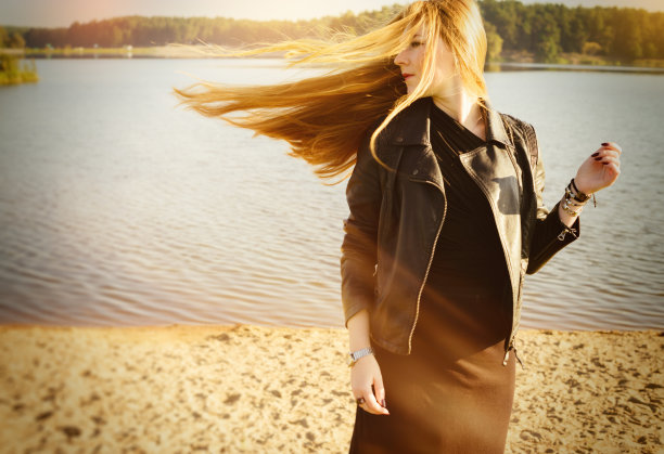 美丽的女人长长的红头发在风的湖边发展图片下载