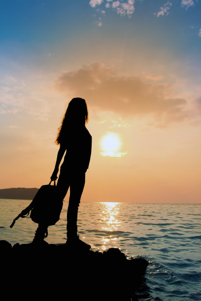 日落时背包女孩的剪影图片下载