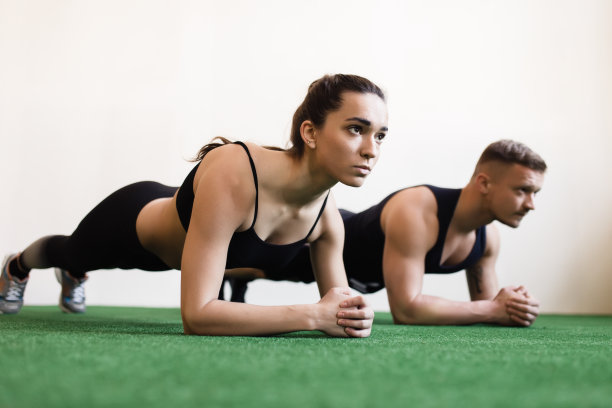 男人和女人在健身房做平板支撑运动图片下载