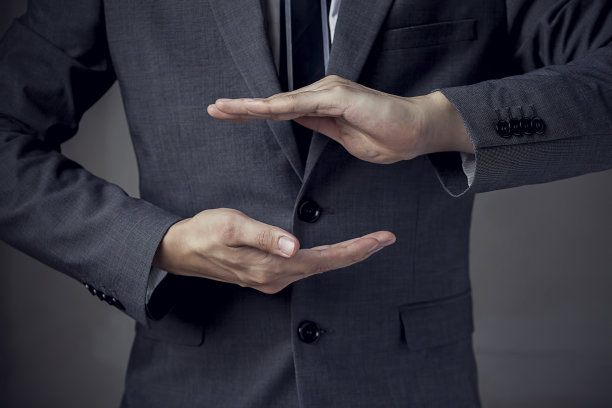 穿着西装的商人双手保护着什么图片下载