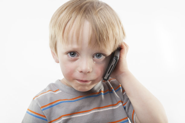 大眼泪男孩在手机上哭泣图片下载