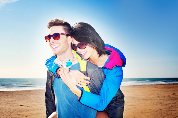 在海滩上背着她的伴侣的男人图片下载