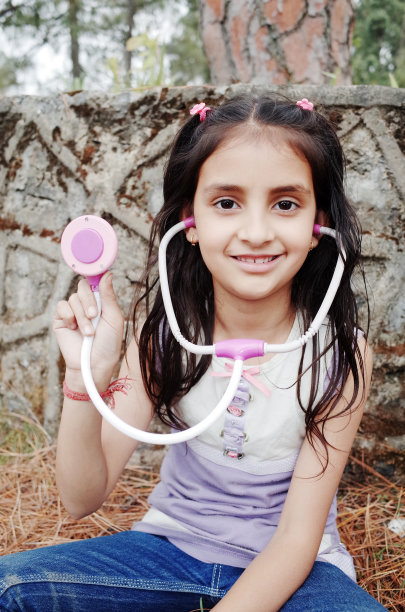 可爱的印度小女孩扮演医生。图片下载