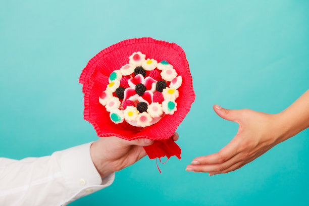 男人给女人糖果束花的特写。图片下载