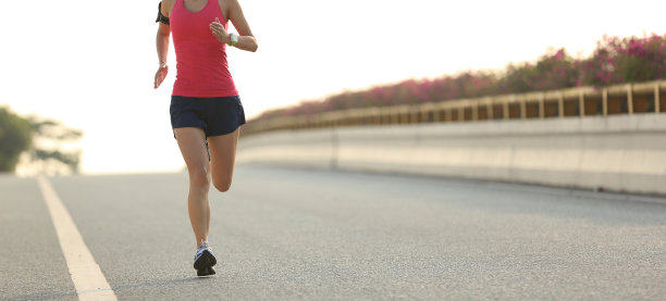 年轻的健身女性在城市道路上跑步图片下载