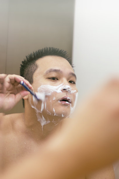 一名日本男子在镜子前刮胡子。图片下载