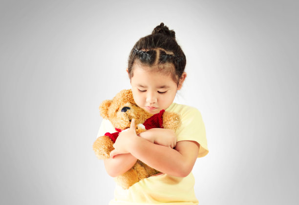 悲伤的小女孩独自抱着泰迪熊图片下载