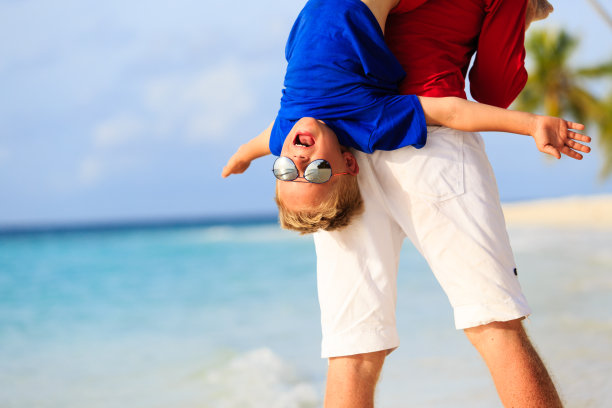 父亲和快乐的小儿子在海滩上玩耍图片下载