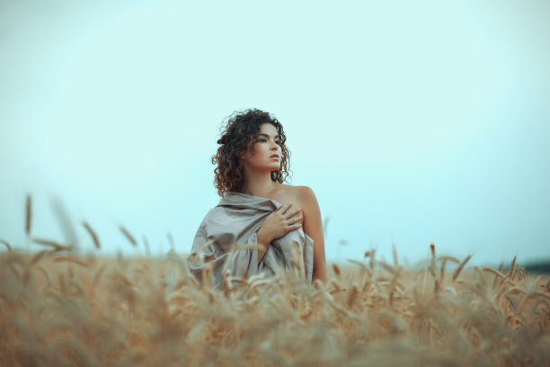 女孩在田野里盖着一块布。图片下载