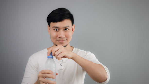 一个亚洲人在喝水。图片下载