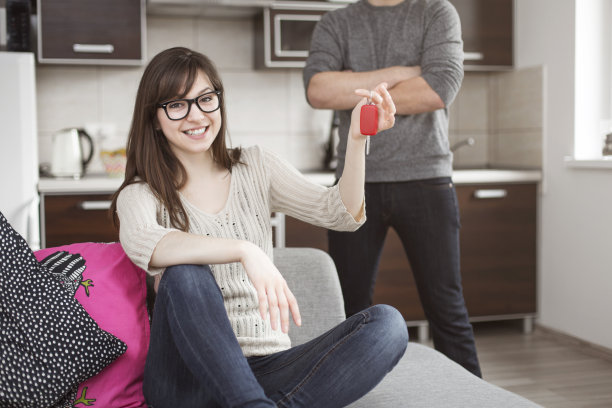 微笑的女人坐着，拿着车钥匙图片下载