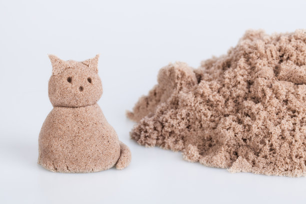 白色背景上湿沙上的猫雕塑图片下载