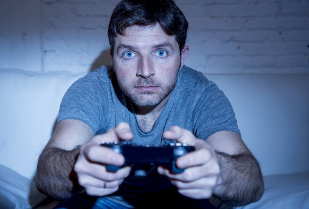 年轻人兴奋地玩电子游戏使用遥控操纵杆图片下载