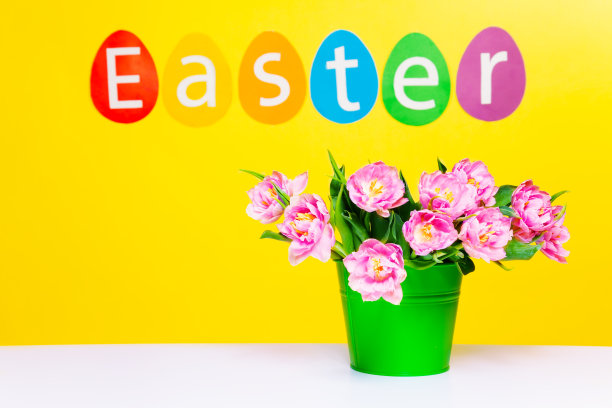 粉红色的花在绿色的花盆上放在桌子上，字复活节图片下载