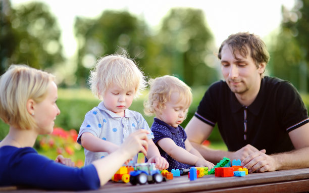 年轻的家庭和他们的孩子玩玩具图片下载