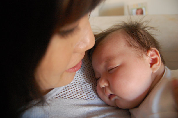 小男孩睡在妈妈的胸前图片下载