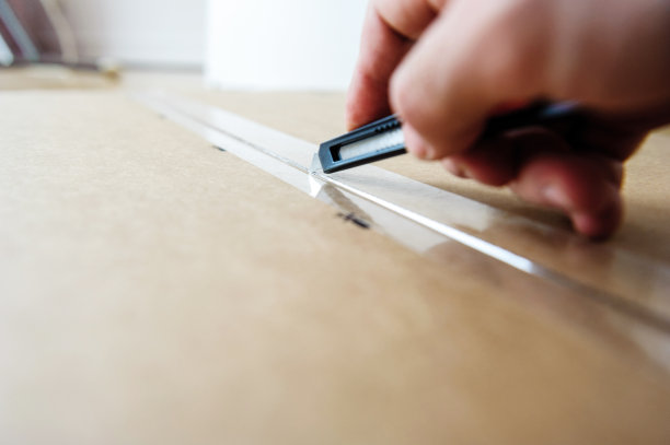 男人用锋利的切刀切纸板图片下载