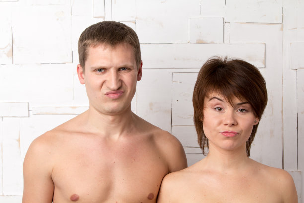 一对情绪不满的年轻夫妇靠近白色的墙图片下载