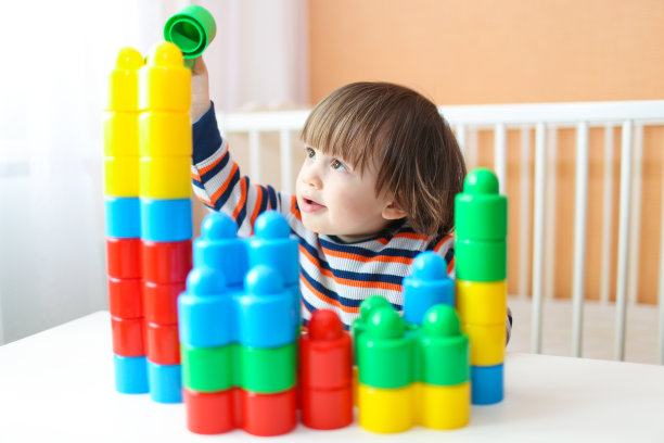 快乐的小男孩玩塑料积木图片下载