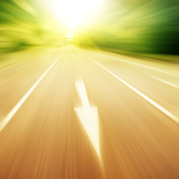 夕阳西下时，移动着交通标志的道路变得模糊了。图片下载