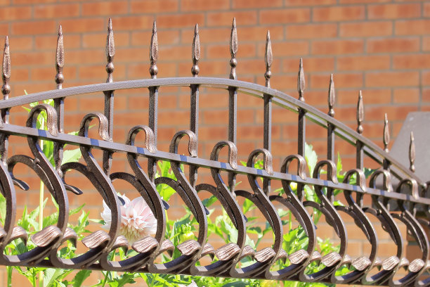 墙壁背景上的金属锻造栅栏图片下载