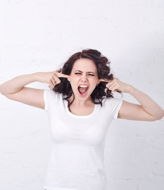 女孩尖叫着，用手捂住耳朵。图片下载