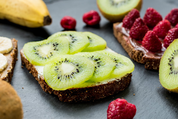 用覆盆子、香蕉和猕猴桃祝酒。健康的生活方式和素食的概念图片下载