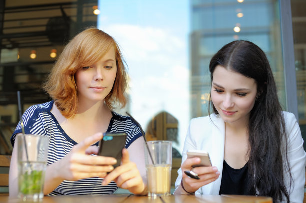 两个小女孩在用智能手机图片下载