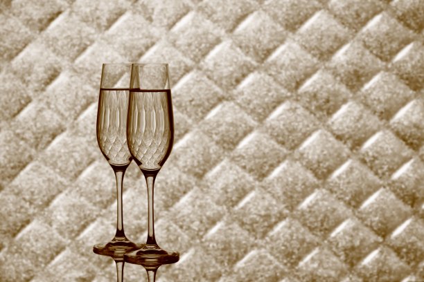 两杯香槟酒杯放在模糊的格子背景上图片下载