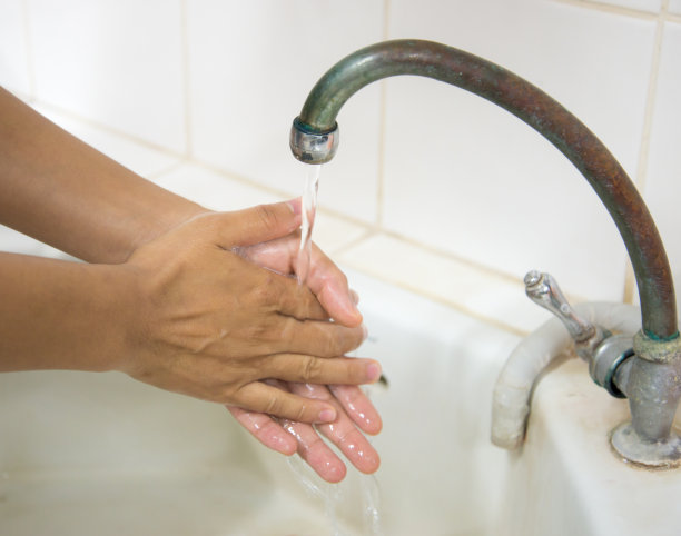 在流动的水中用肥皂洗手。图片下载