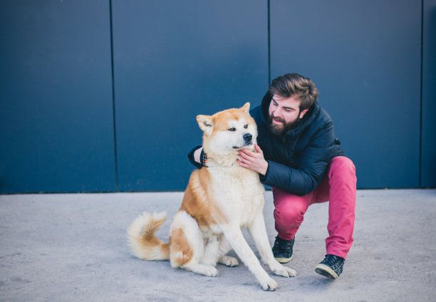 长胡子的男人在户外抚摸他的狗图片下载