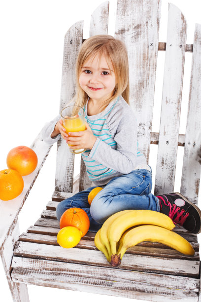 小女孩坐在椅子上喝果汁图片下载