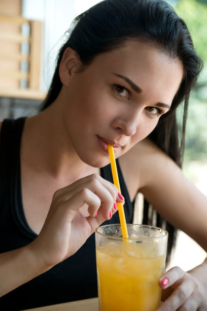 年轻的欧洲女人在咖啡馆喝柠檬水图片下载